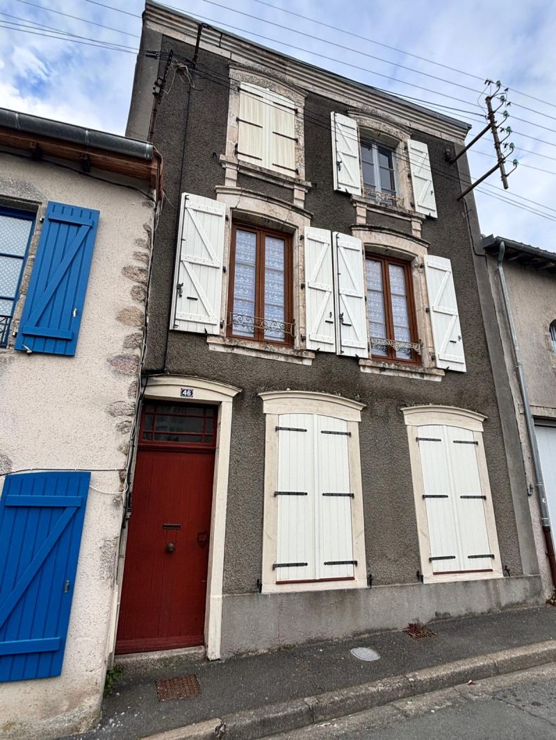 Façade d’une maison de ville ancienne en enduit sombre avec volets blancs, montrant un bon état général mais typique d’une rénovation avec enduit ciment sur maçonnerie traditionnelle.