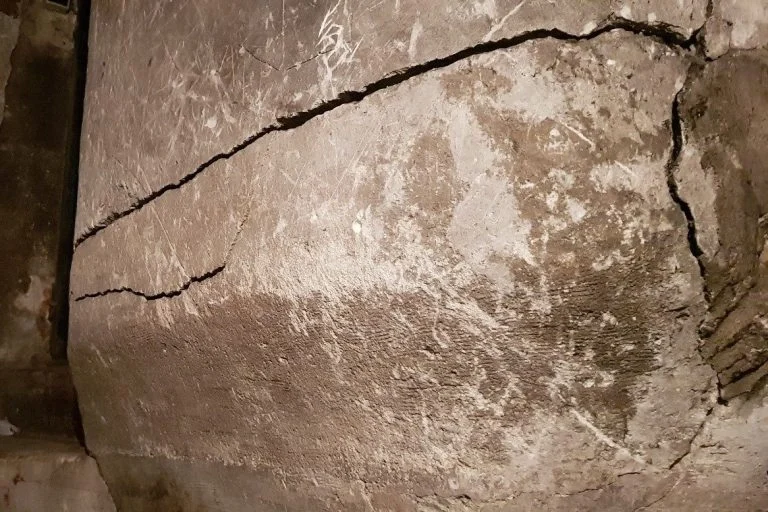 Pile maçonnée en cave au droit d'un escalier fortement fissuré